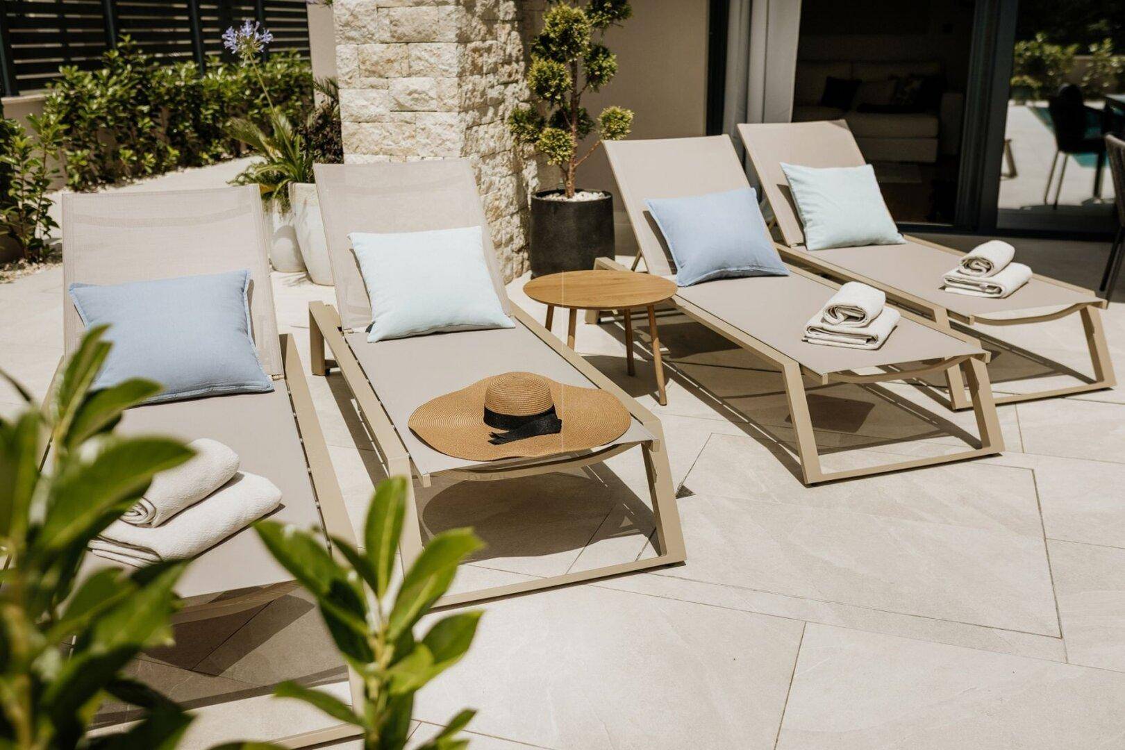 Sonnenliegen auf der hellen Terrasse, bereit für entspannte Stunden im Freien.
