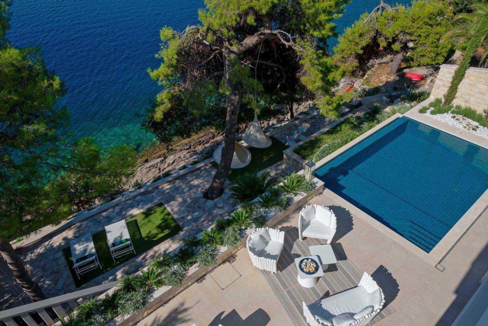 Luftaufnahme der luxuriösen Villa mit Infinity-Pool, Sonnenterrasse und direktem Zugang zum Meer.