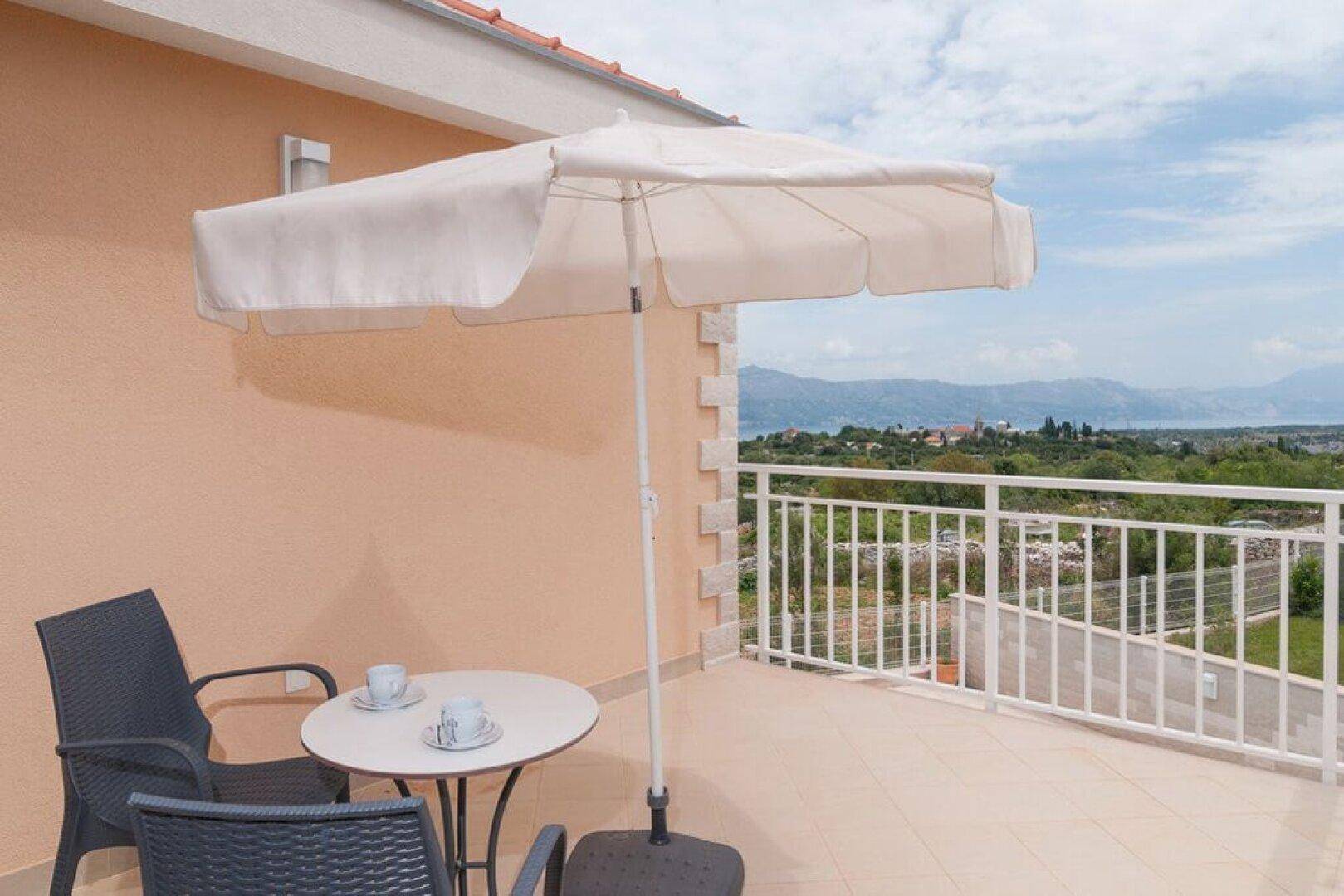 Gemütlicher Balkon mit Sitzgelegenheiten und weitem Blick auf die Landschaft und das Meer.