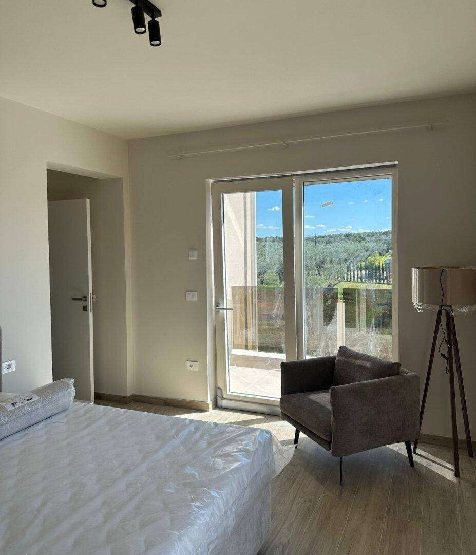 Helles Schlafzimmer mit Zugang zum Balkon und einem schönen Blick auf die grüne Umgebung.