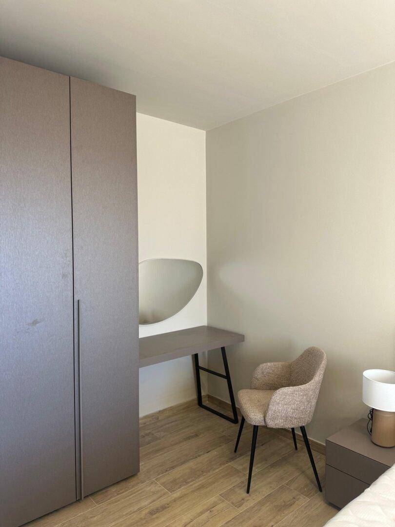 Schlafzimmerecke mit modernem Kleiderschrank und einem stilvollen Schminktisch mit Spiegel.
