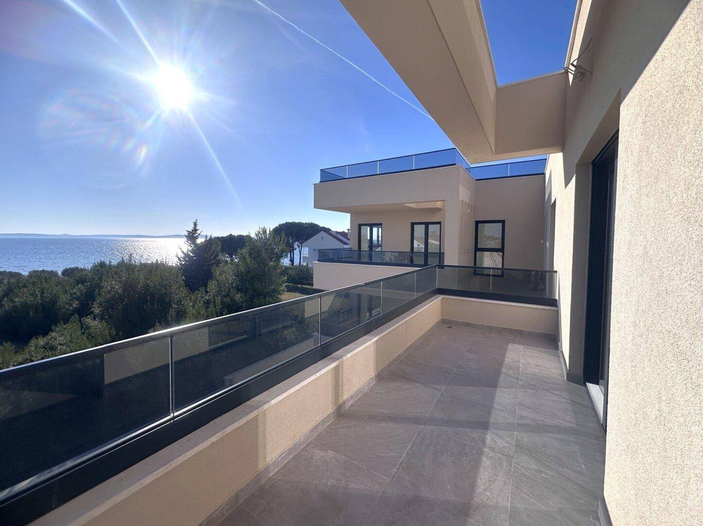 Geräumige Terrasse mit Meerblick und moderner Architektur des Gebäudes.