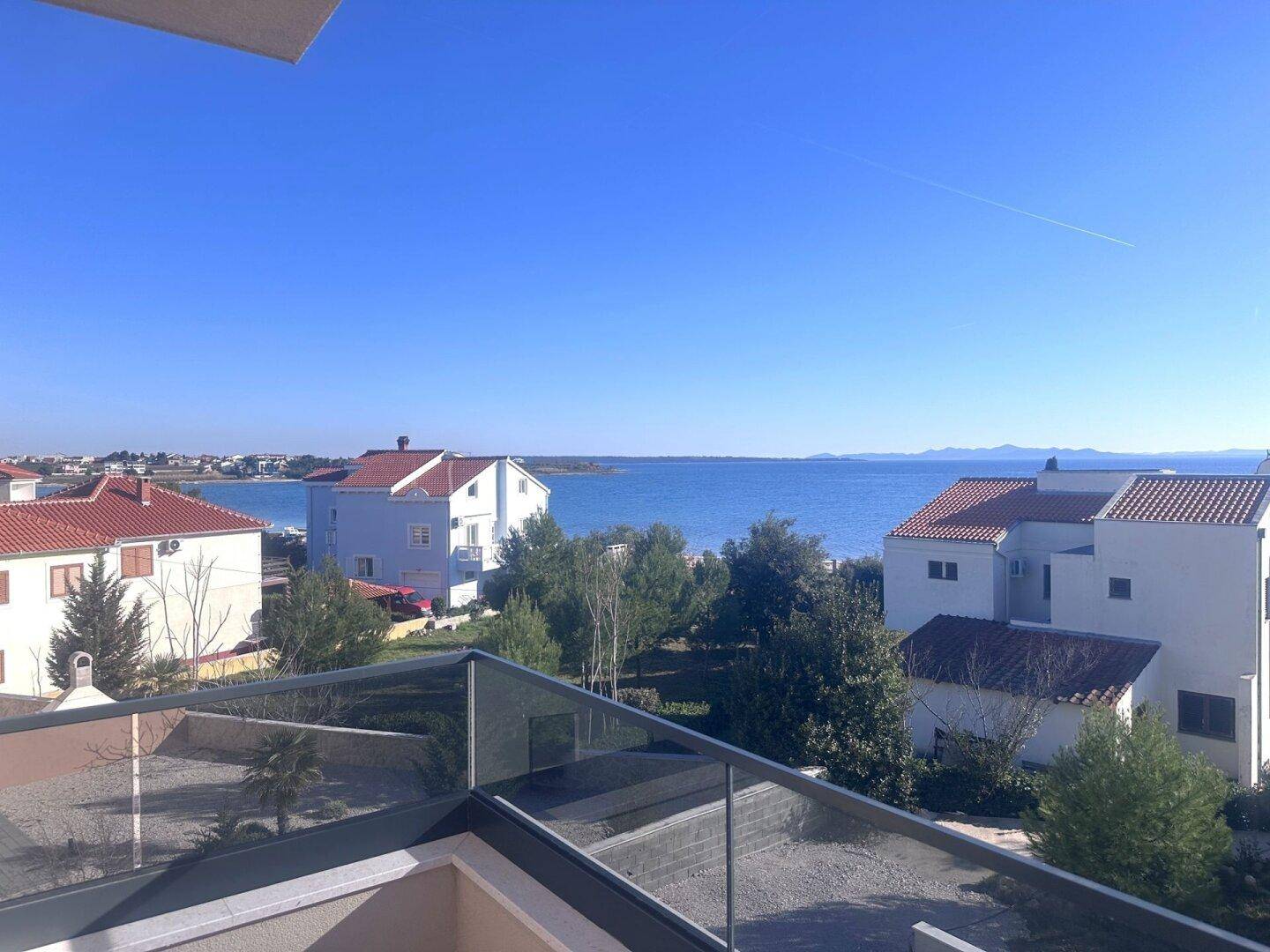 Panoramablick vom Balkon auf das Meer und die umliegende Küstenlandschaft.