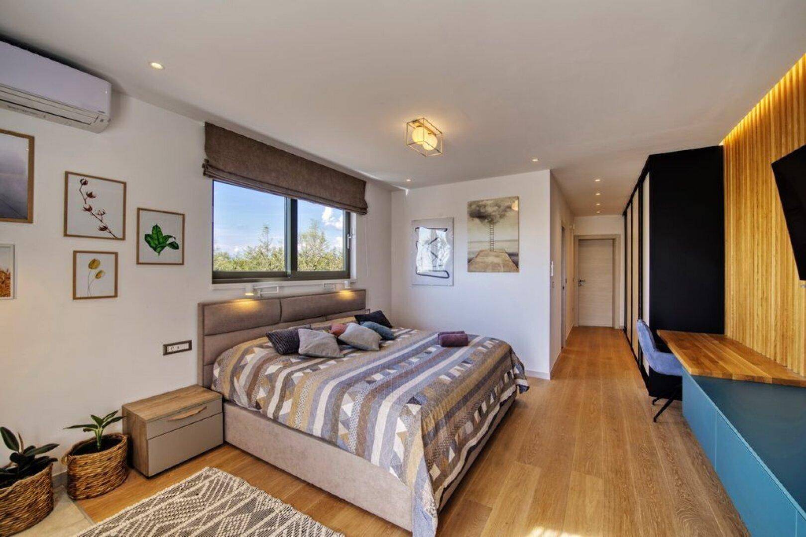 Modernes Schlafzimmer mit Holzboden, Klimaanlage und stilvoller Wandverkleidung.