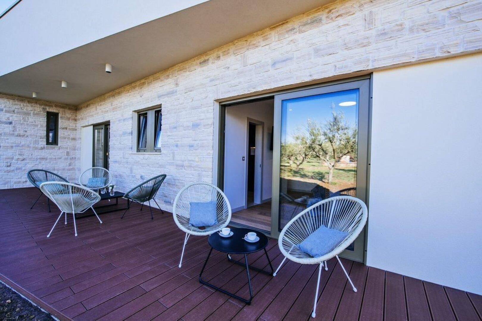 Gemütliche Terrasse mit modernen Sitzgelegenheiten und Blick auf die umliegende Natur.