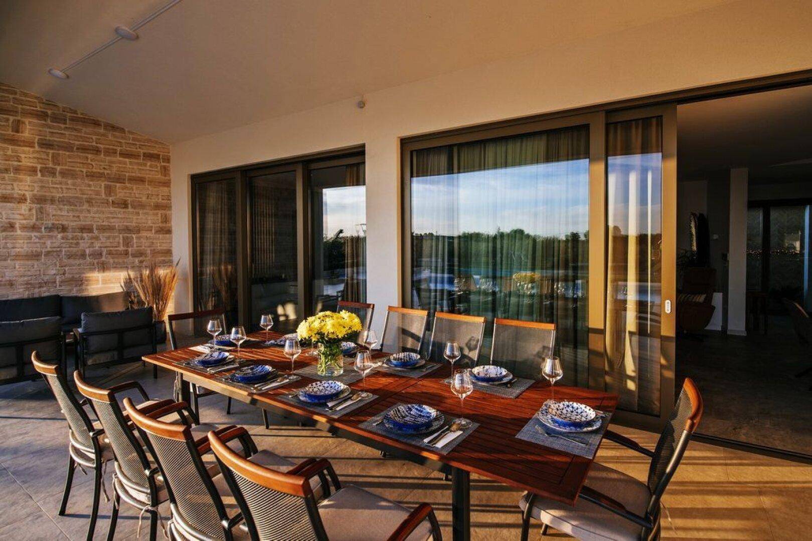 Großer Esstisch im Freien auf der Terrasse, ideal für Mahlzeiten mit Familie und Freunden.