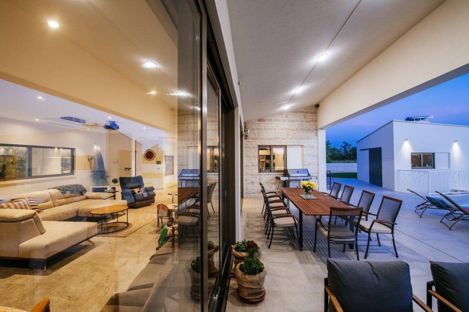 Überdachte Terrasse mit Essbereich im Freien und direktem Zugang zum Wohnbereich.