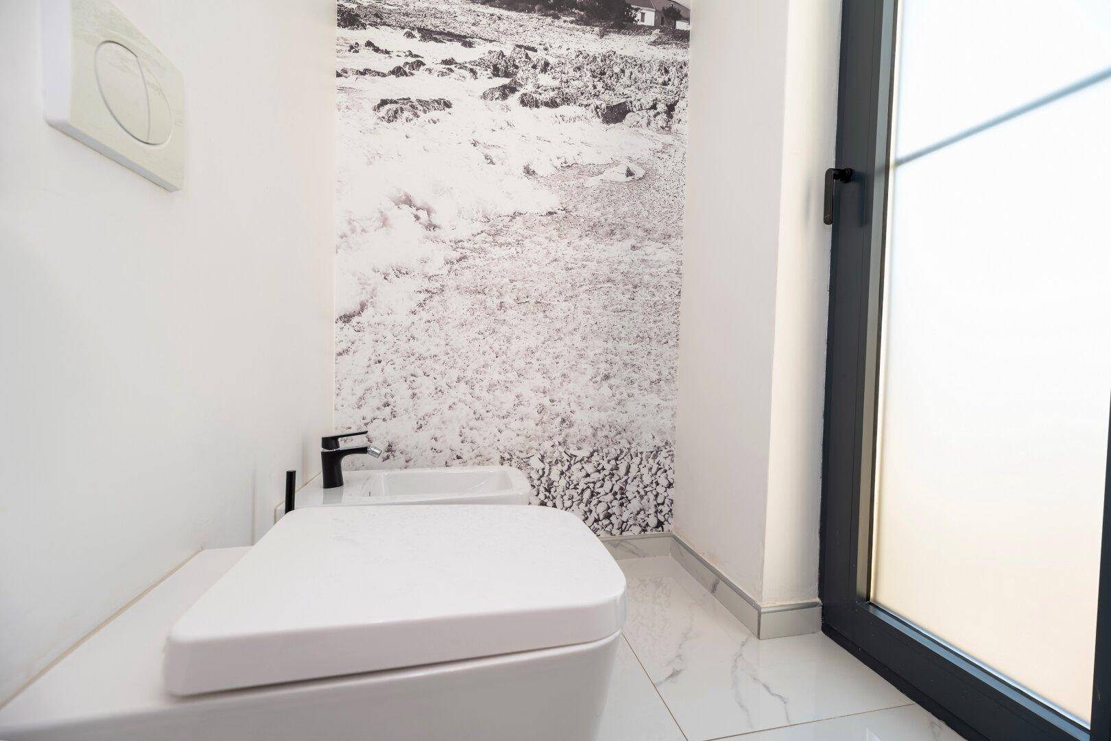 Modernes Gäste-WC mit Wand-WC, Bidet und großformatiger Wanddekoration.
