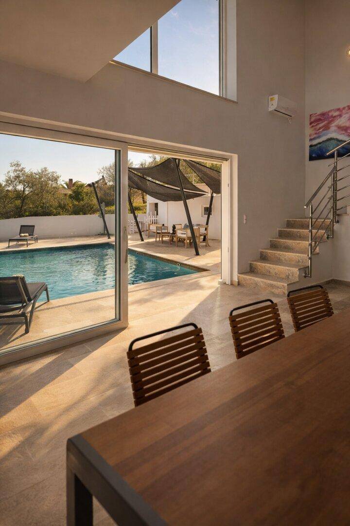 Heller Innenbereich mit Treppe und Zugang zum Poolbereich.