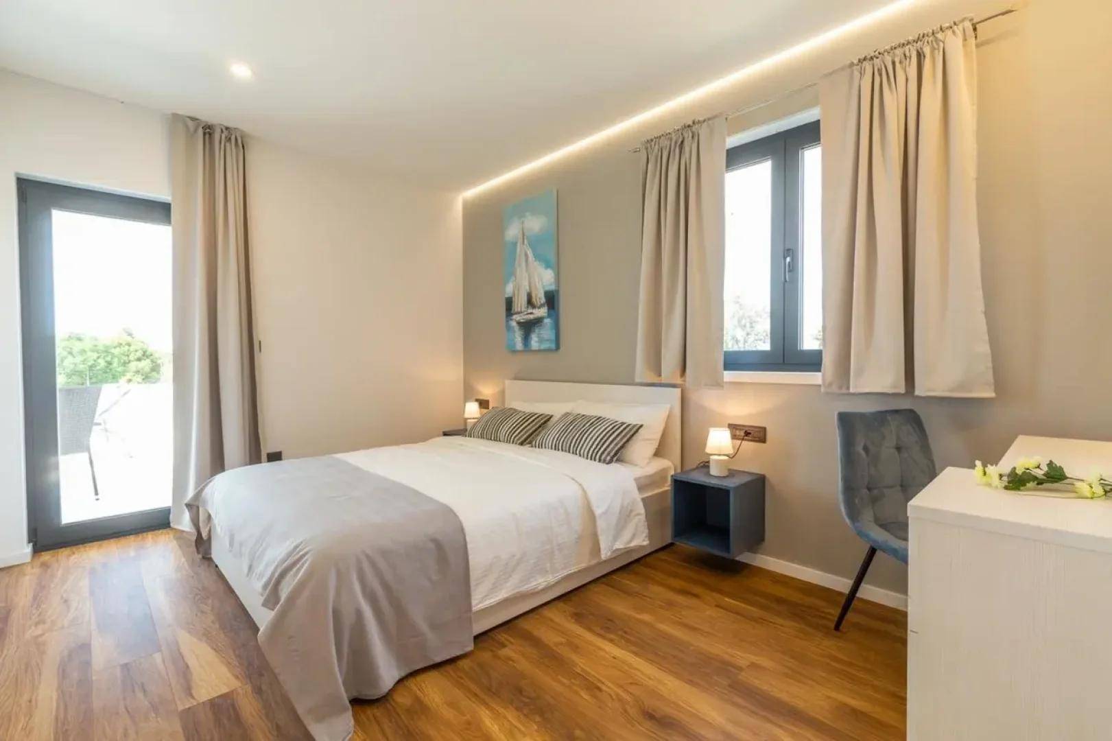 Gemütliches Schlafzimmer mit Doppelbett, Schreibtisch und direktem Zugang zu einem Außenbereich.
