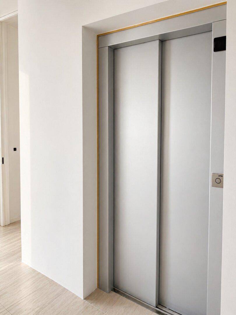 Heller Flur mit Zugang zu einem modernen Aufzug, der die Etagen verbindet.