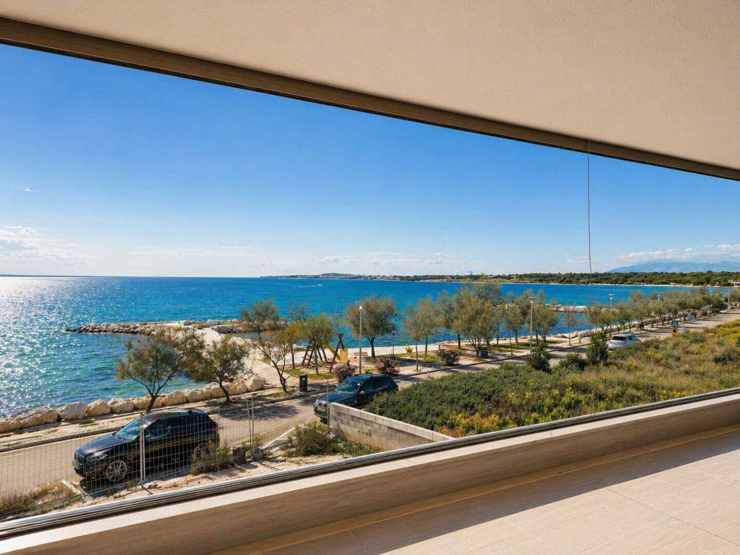 Balkon mit weitem Blick auf das glitzernde Meer und die Küstenlandschaft.