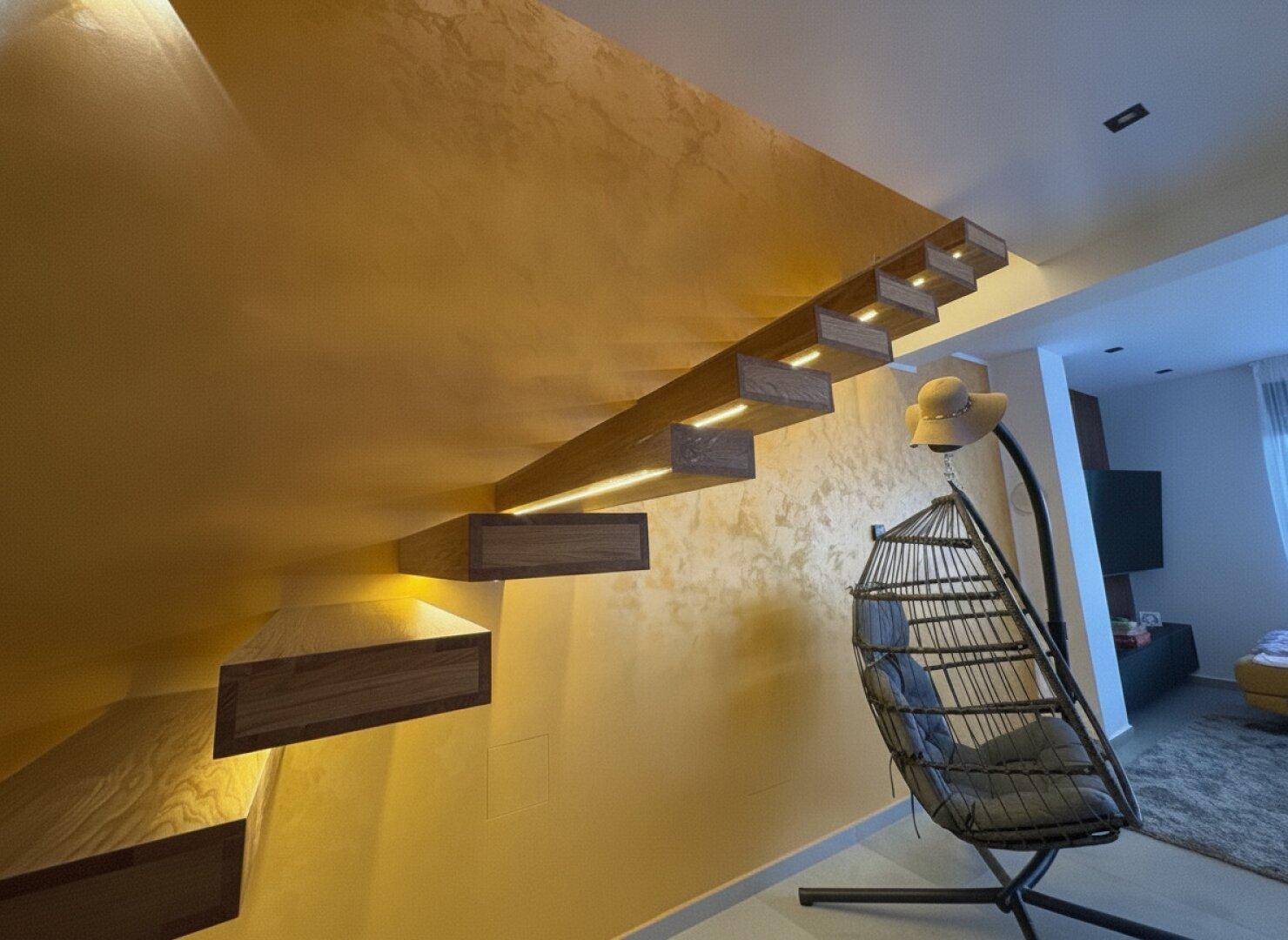 Moderne Treppe mit schwebenden Holzstufen und integrierter Beleuchtung in einem hellen Flur.