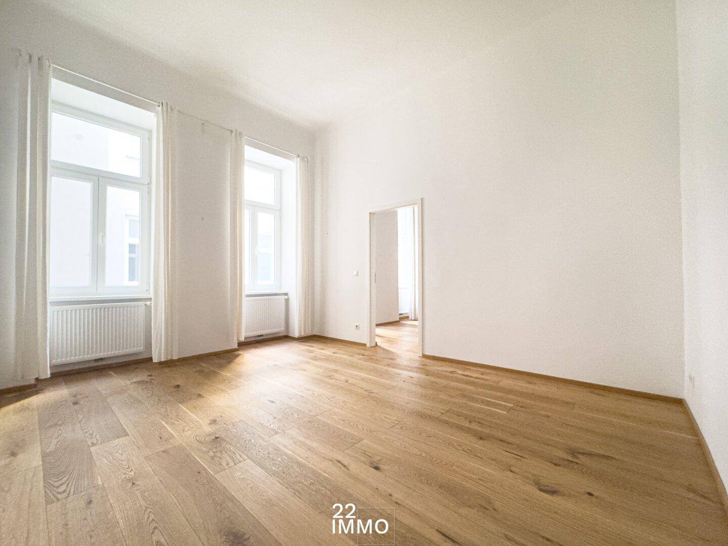 Geräumiger, heller Raum mit hohen Decken und elegantem Parkettboden, bereit zur individuellen Gestaltung.