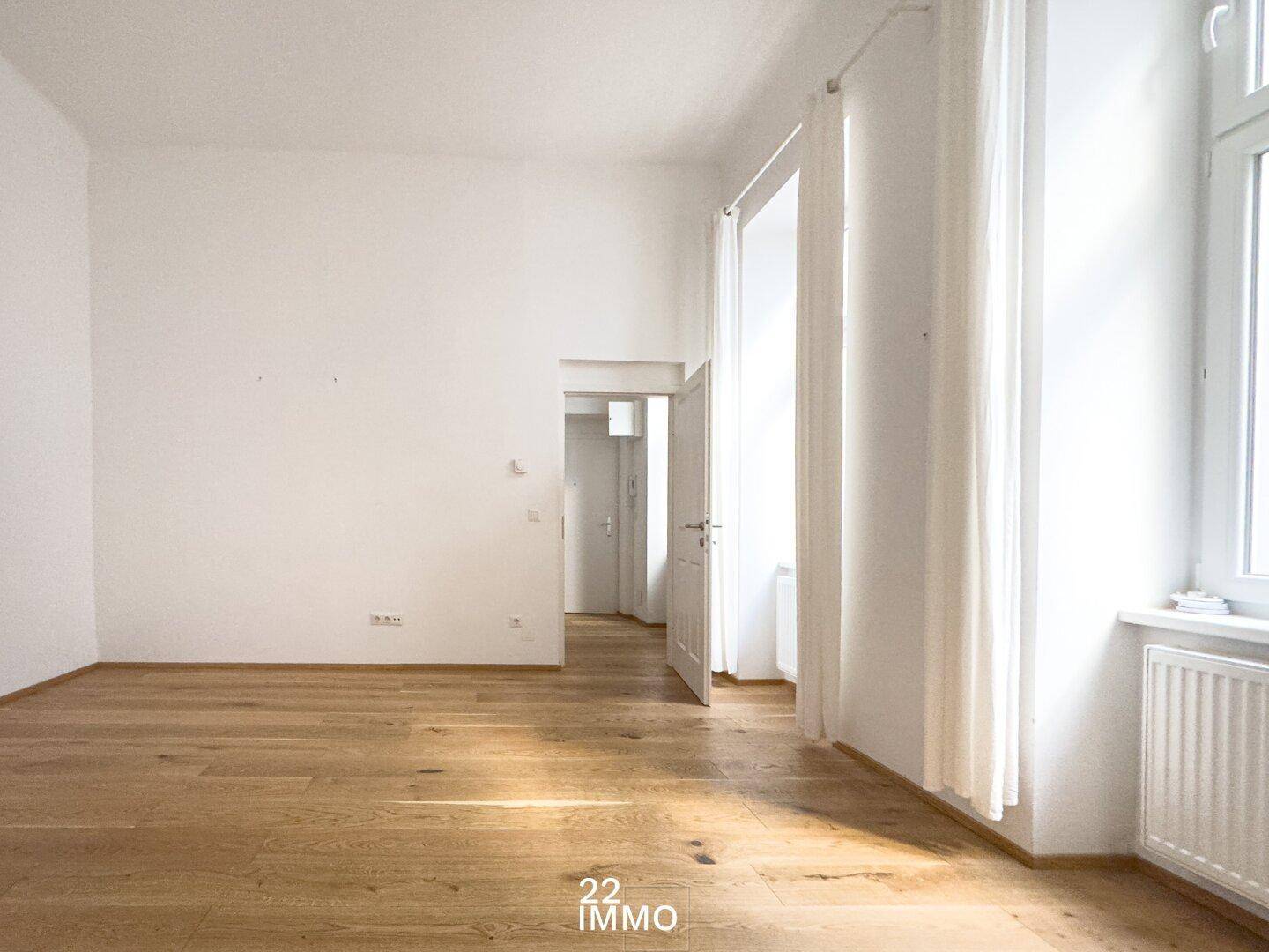 Heller Raum mit Parkettboden und hohen Decken, bietet viel Potenzial für individuelle Einrichtungsideen.