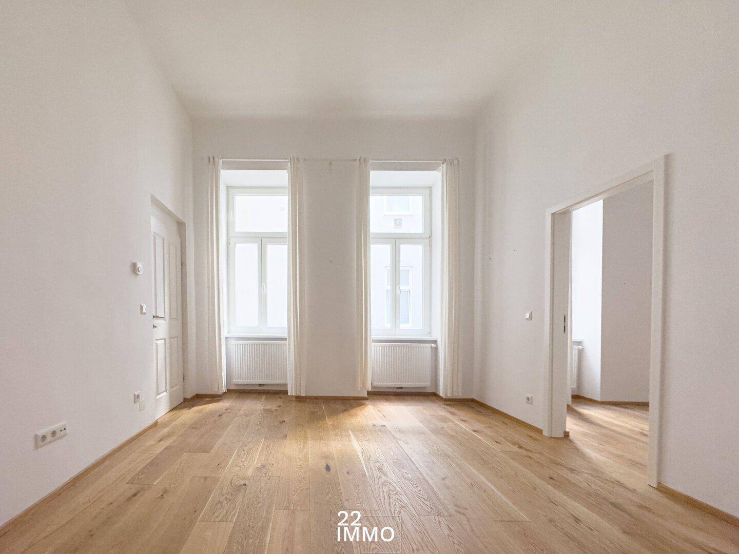 Geräumiger, heller Raum mit hohen Decken und elegantem Parkettboden, bereit zur individuellen Gestaltung.