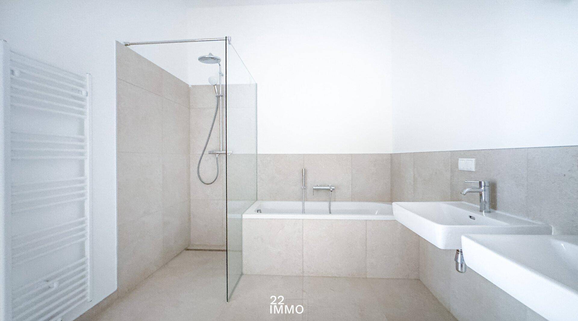Modernes Badezimmer mit begehbarer Dusche, Badewanne und Doppelwaschbecken.