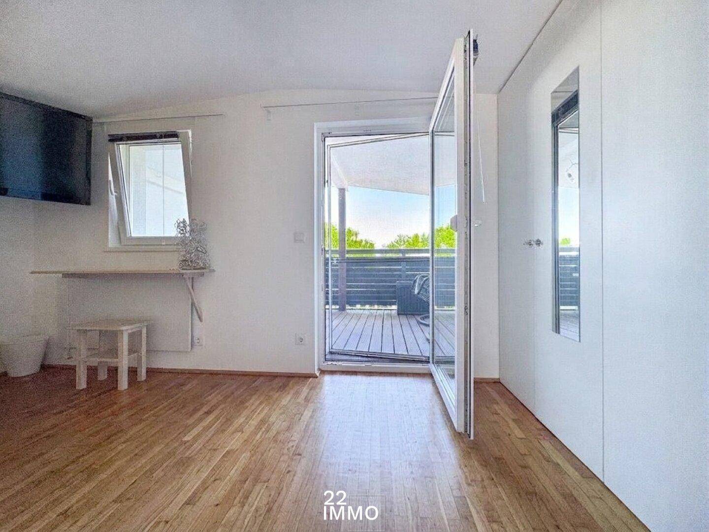 Helles Schlafzimmer mit Holzboden und direktem Zugang zu einem Balkon mit schöner Aussicht.