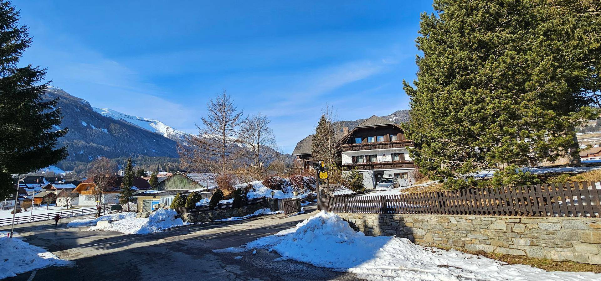 Weitläufige Ansicht des Anwesens und der Umgebung im Winter mit verschneiten Bergen und Dorf.