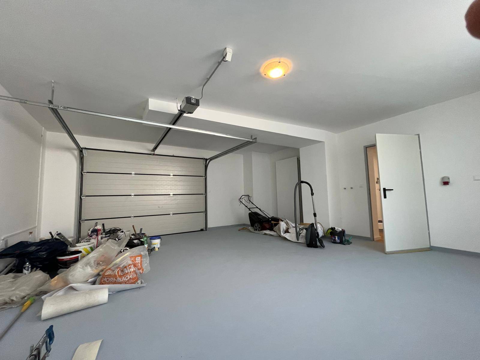 Geräumige Garage mit automatischem Tor und ausreichend Platz für Fahrzeuge und Lagerung.