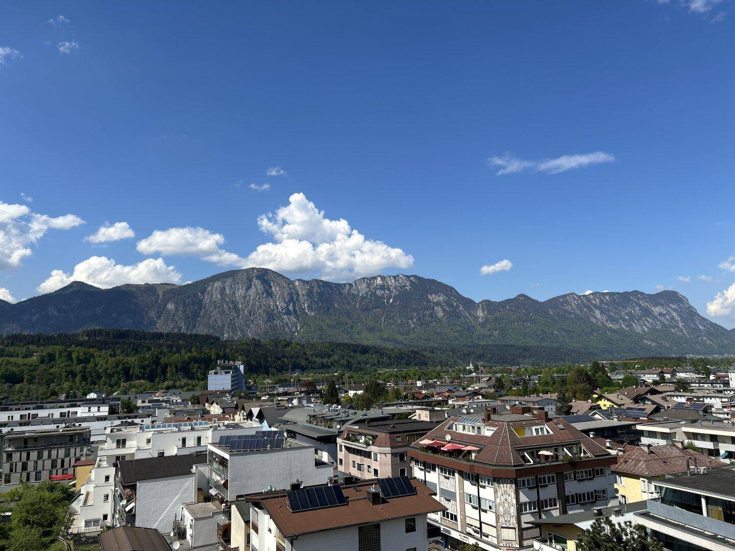 Panoramablick über die Stadt und die majestätischen Berge unter blauem Himmel.