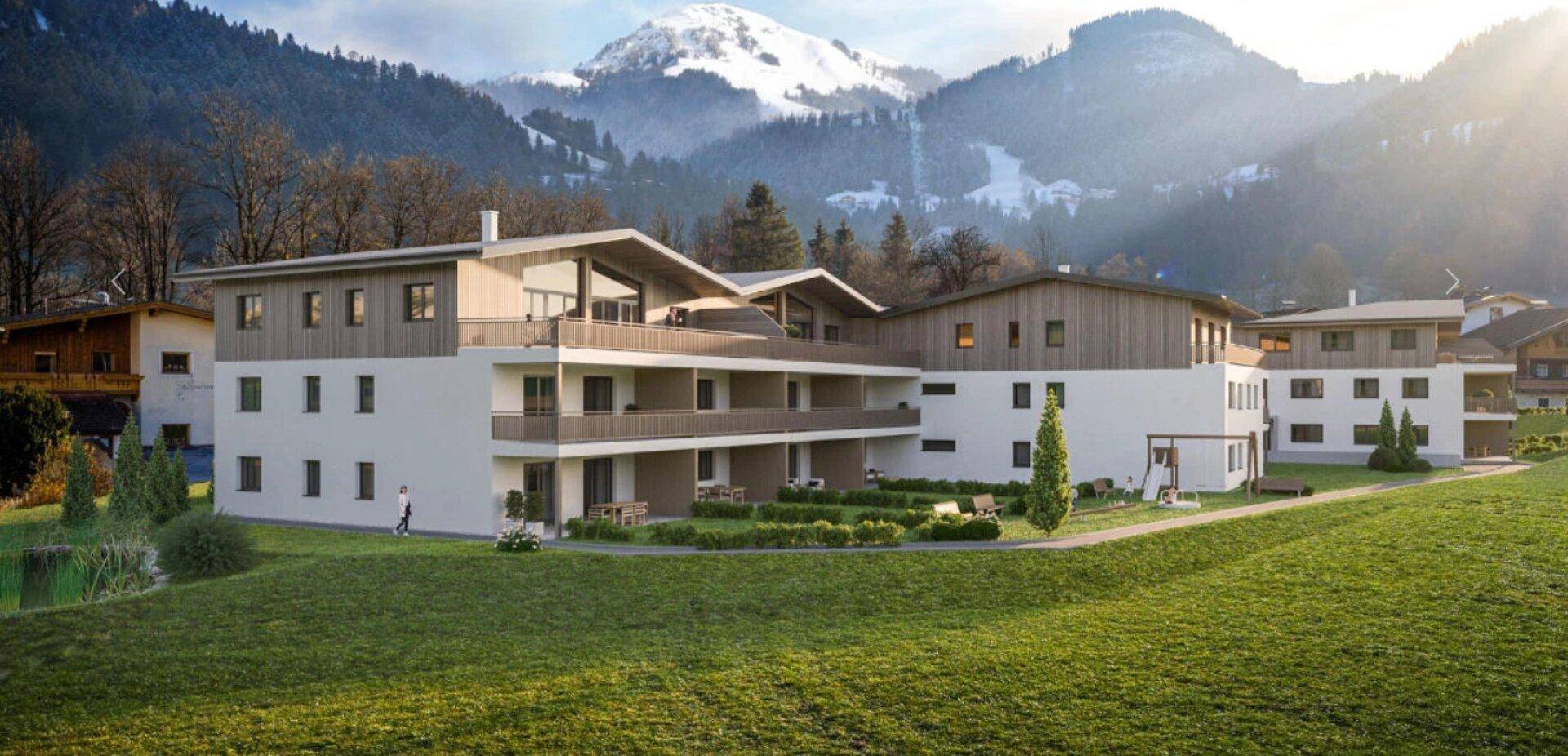 Moderne Wohnanlage in alpiner Landschaft mit Balkonen und grüner Umgebung.