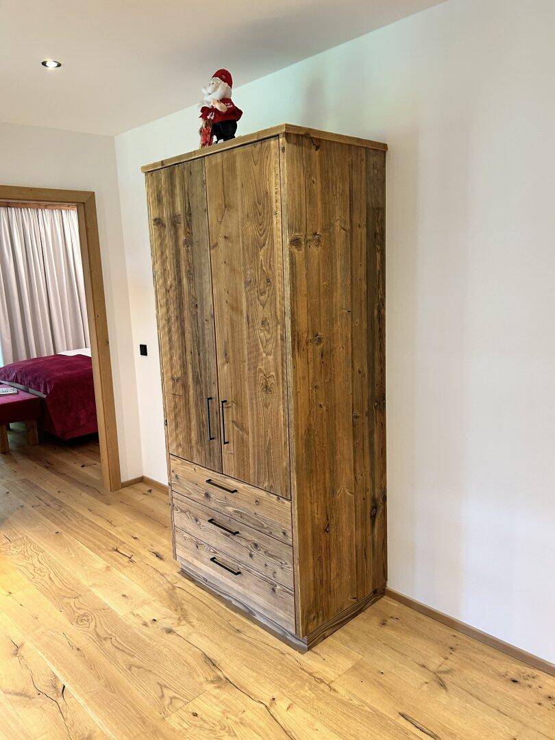 Geräumiger Flur mit rustikalem Holzschrank und Holzboden, bietet viel Stauraum und alpine Atmosphäre.