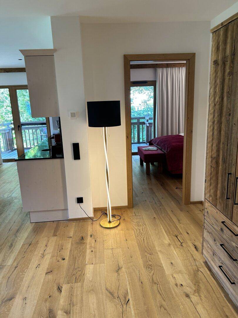 Heller Flur mit moderner Stehlampe und Blick in ein angrenzendes Schlafzimmer, offen und einladend.