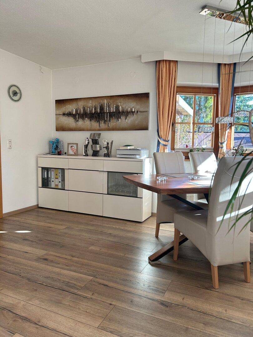Heller Essbereich mit modernem Sideboard, Esstisch und Holzboden, ideal für gesellige Runden.