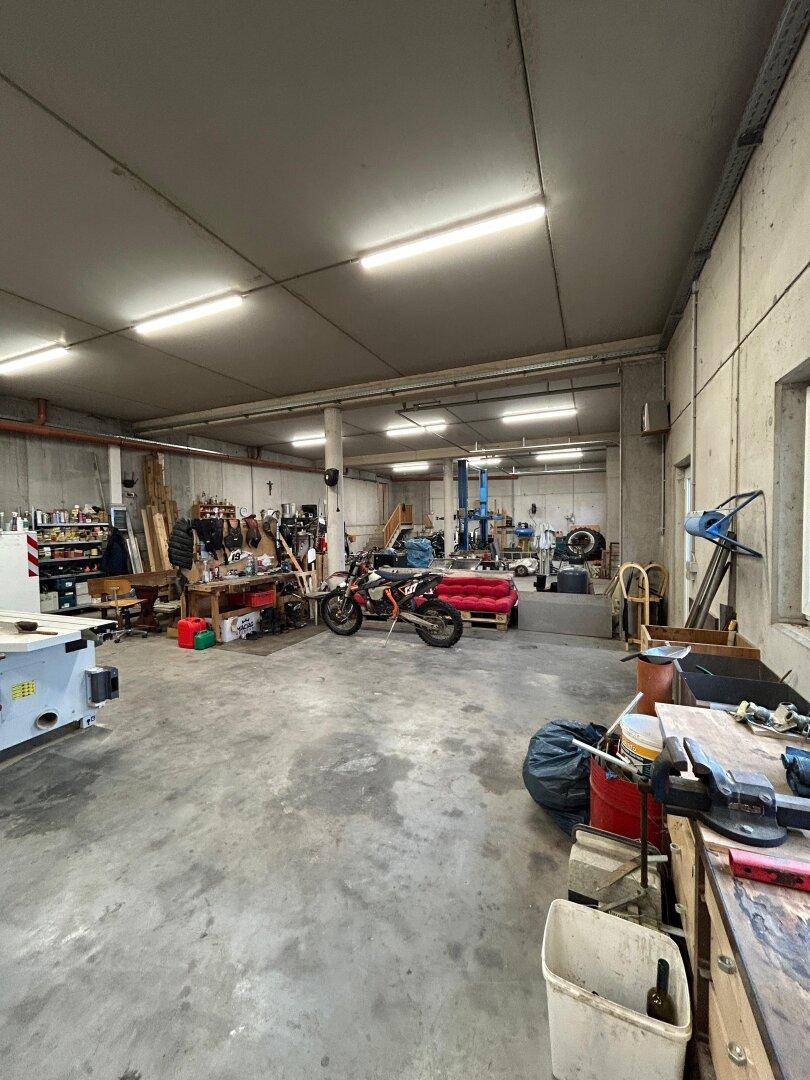 Geräumige Werkstatt mit viel Arbeitsfläche, Werkzeugen und Maschinen.