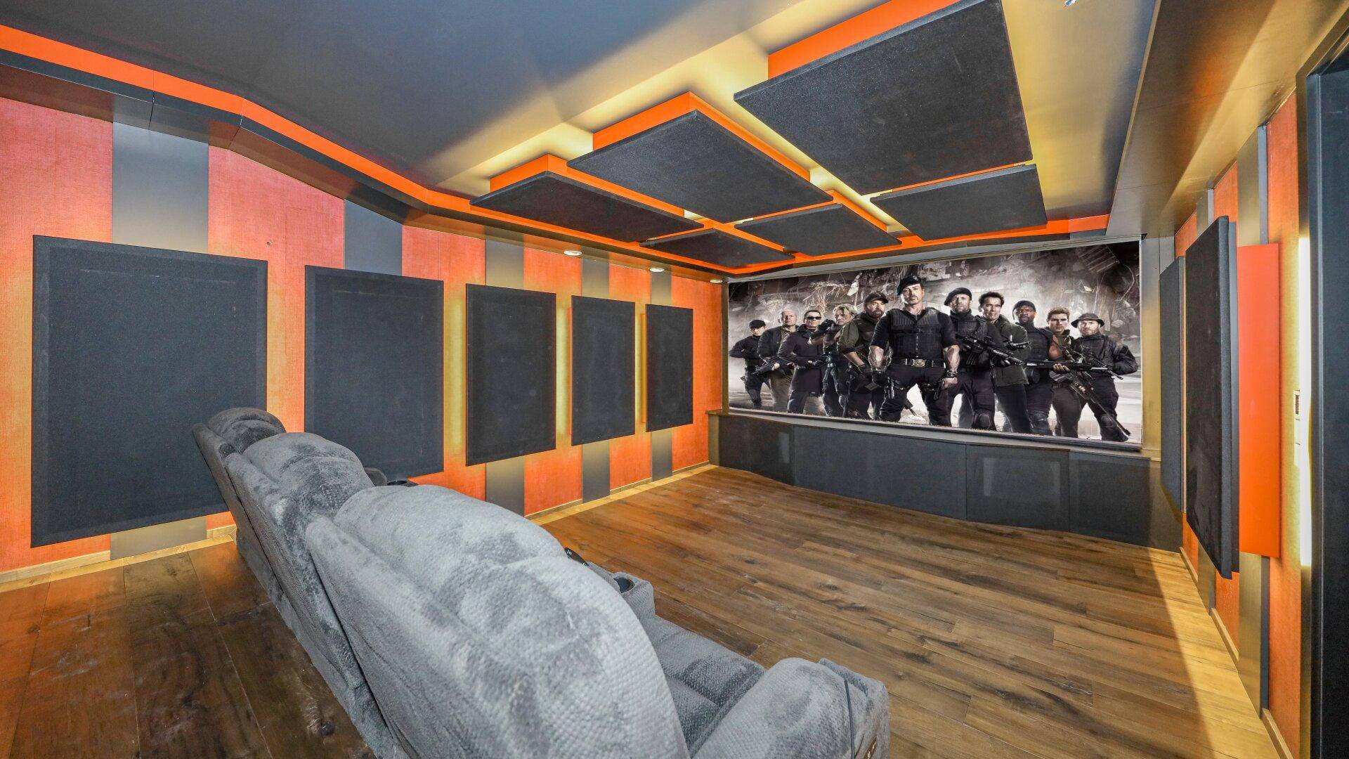 Exklusiver Medienraum mit großer Leinwand, bequemen Sesseln und Akustikpaneelen.
