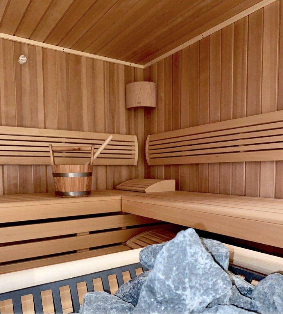 Traditionelle Sauna mit Holzbänken und Saunaofen für entspannende Stunden.