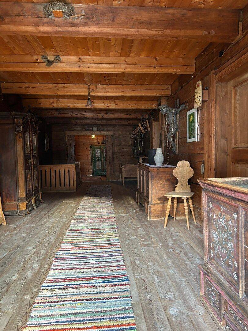 Langer Flur mit Holzboden, Holzwänden und traditionellen Möbeln im Landhausstil.
