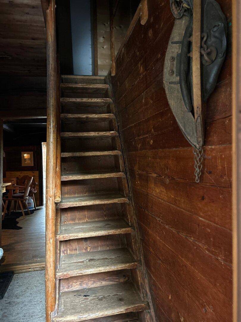 Rustikale Holztreppe in einem traditionellen Haus mit Holzwänden und -böden.