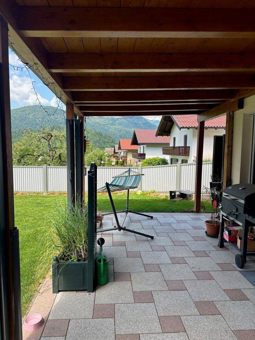 Überdachte Terrasse mit Hängematte und Grillbereich, ideal zum Entspannen im Freien.