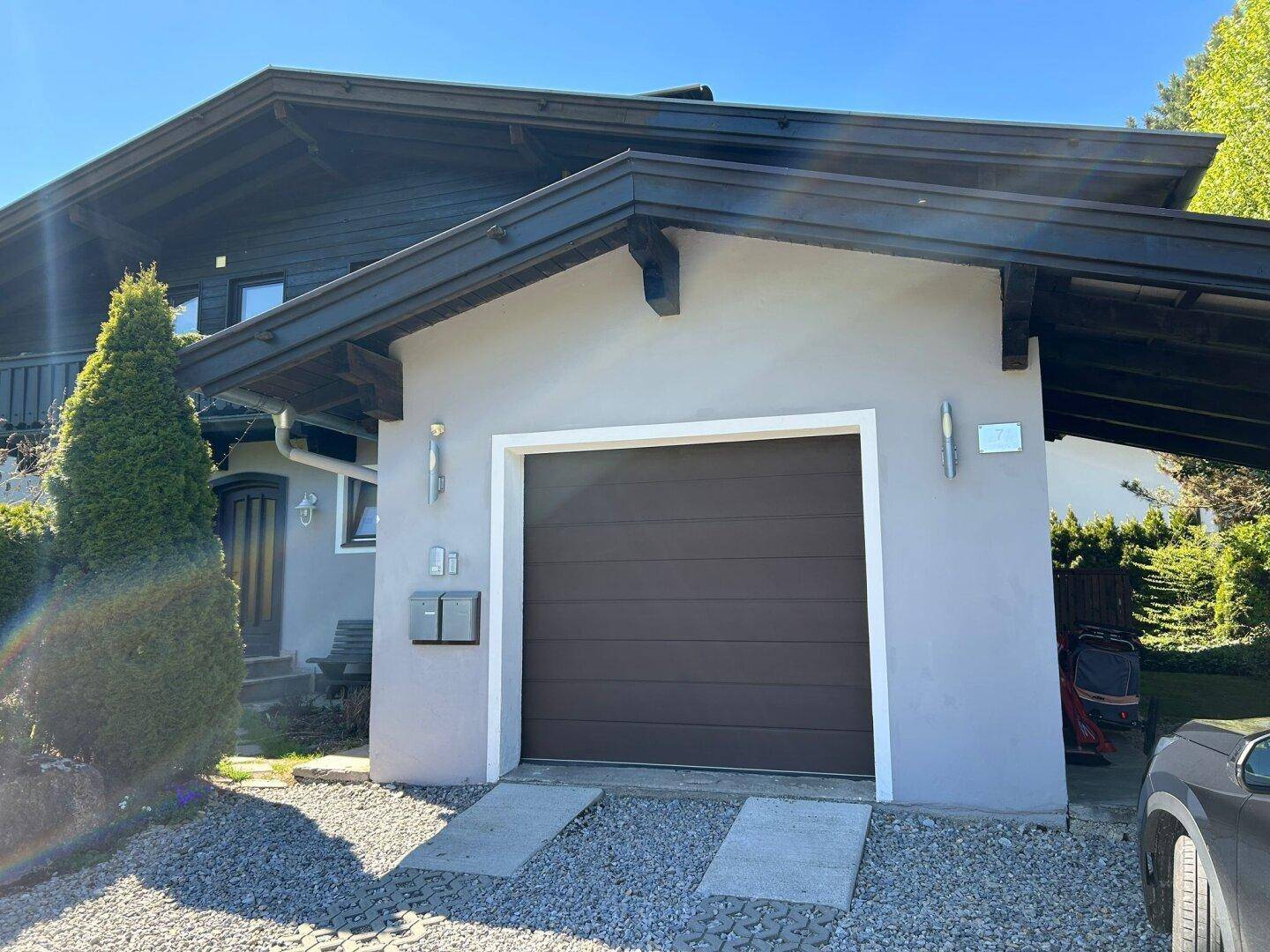 Vorderansicht der Garage und des Eingangsbereichs des Hauses mit gepflegter Auffahrt.