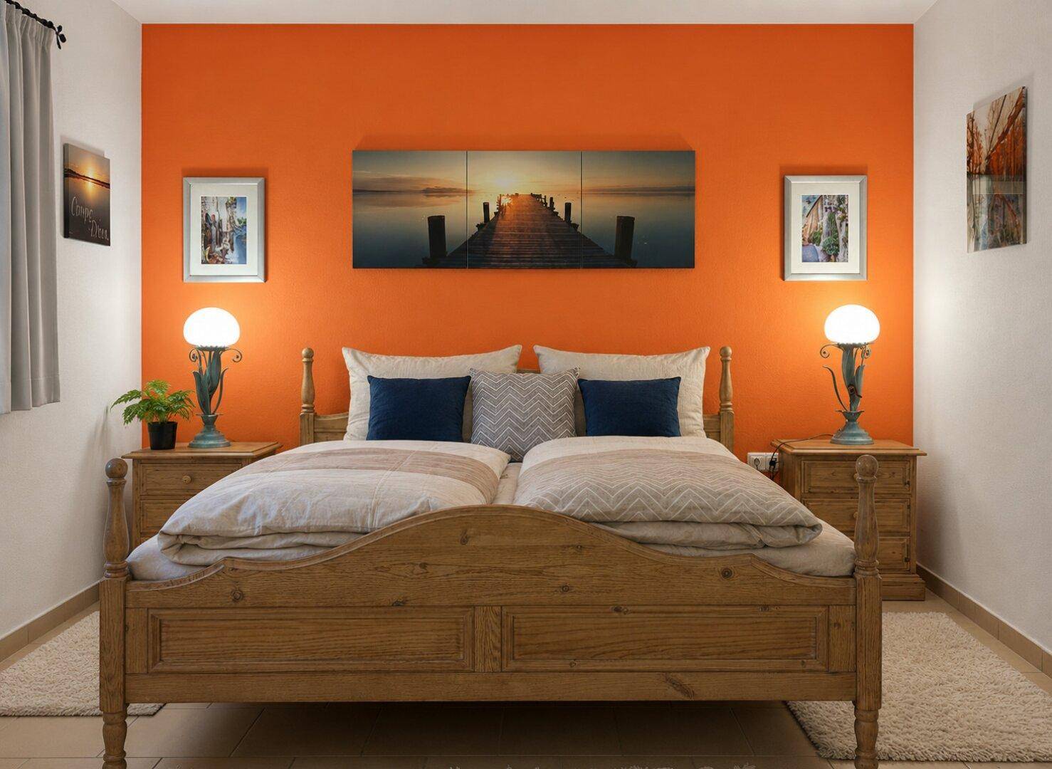 Gemütliches Schlafzimmer mit orangefarbener Akzentwand und traditionellem Holzdoppelbett.