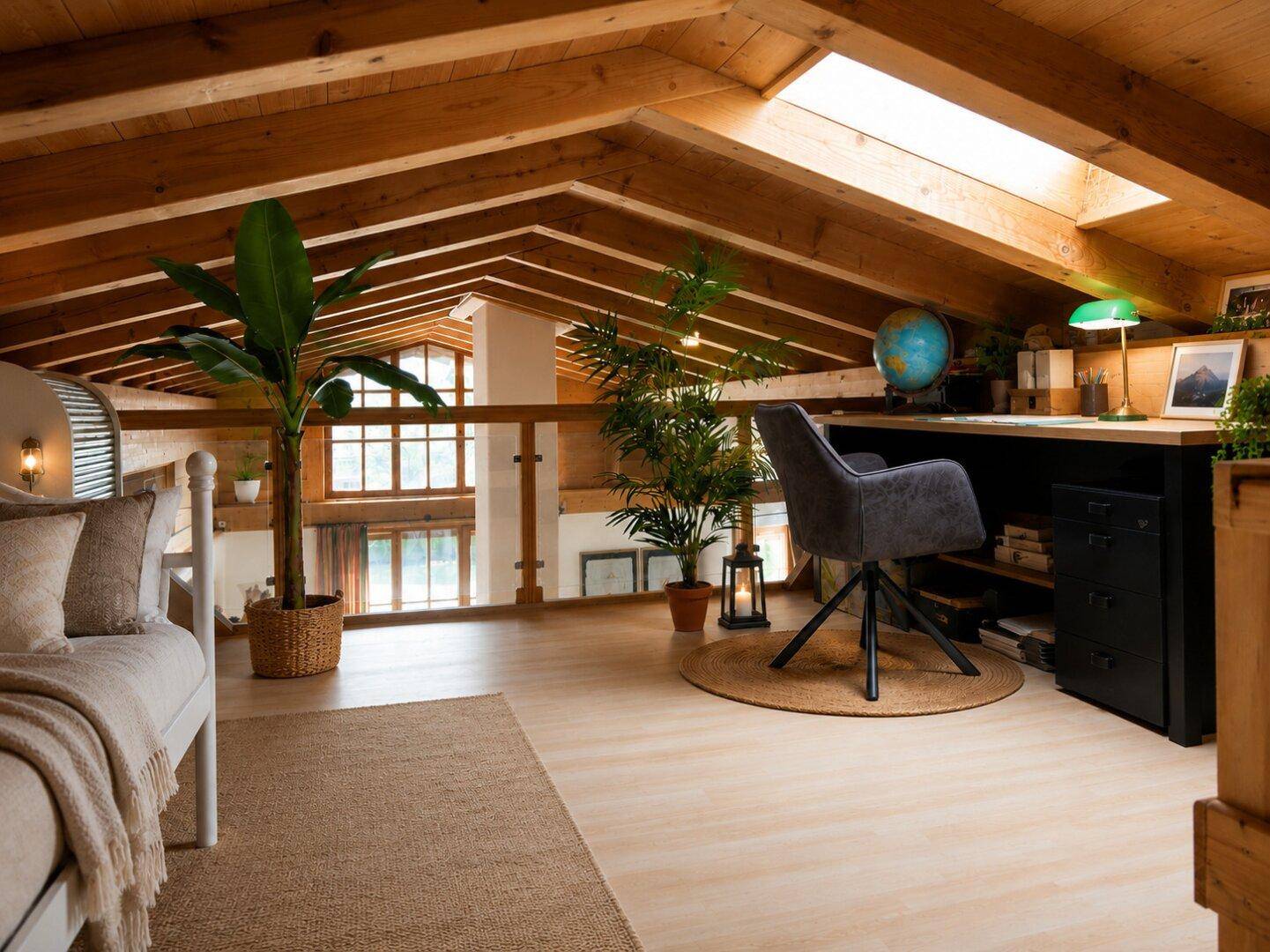 Helles Dachgeschoss-Büro mit Holzbalken, Dachfenster und Blick auf den Wohnbereich.