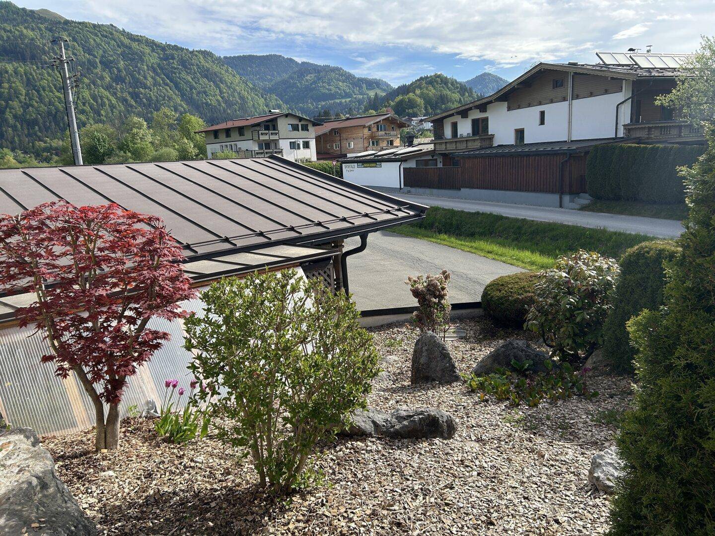 Gepflegter Vorgarten mit Ziersträuchern und Kiesbeet vor dem Haus.