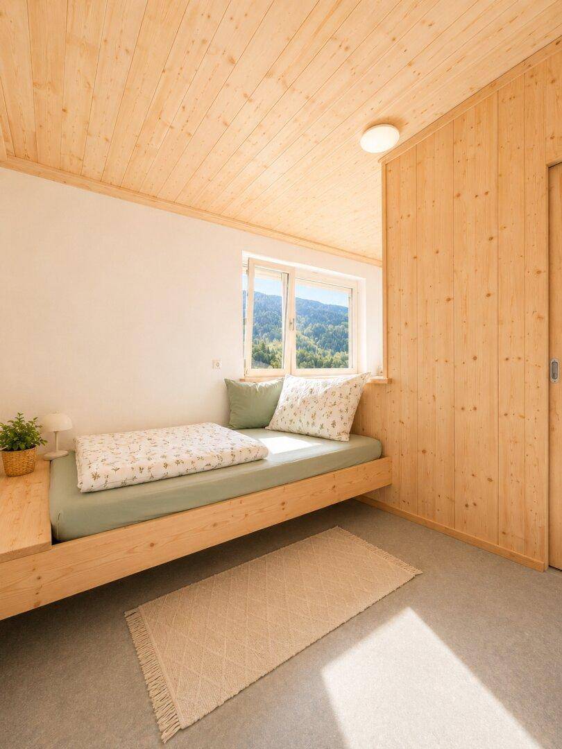Gemütliches Schlafzimmer mit Holzwänden, Holzbett und Blick auf die grüne Berglandschaft.