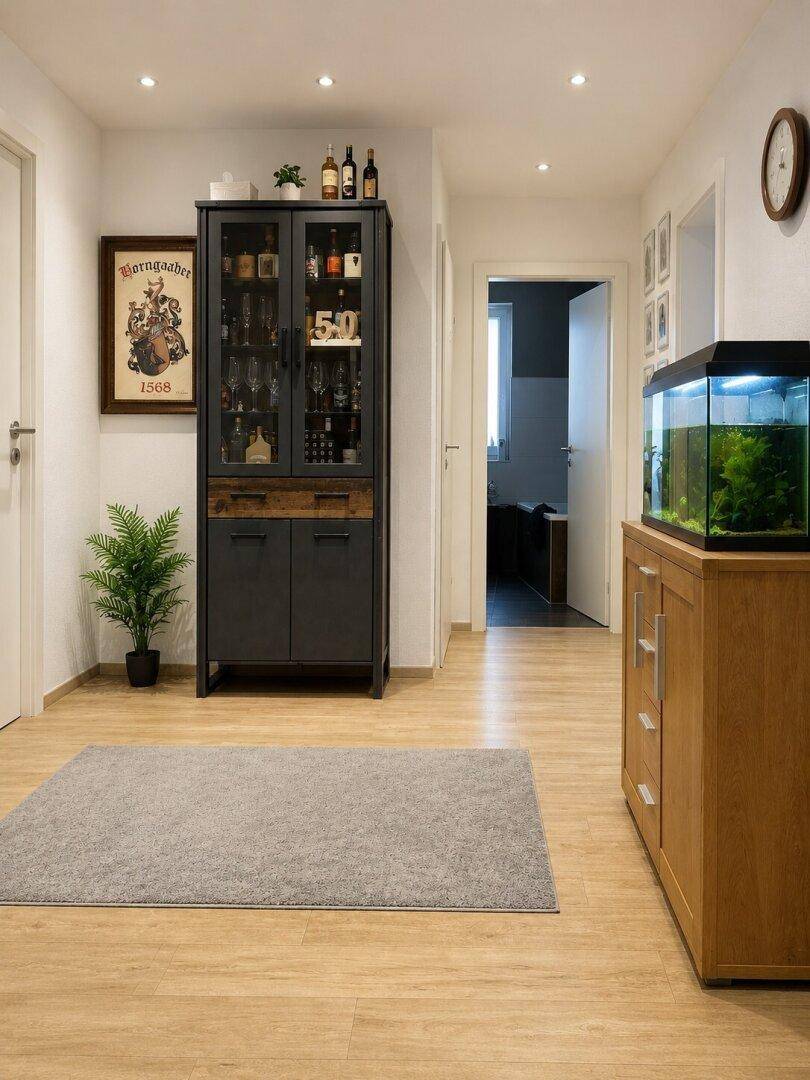 Heller Flur mit Laminatboden, Vitrinenschrank und Aquarium als Dekoration.