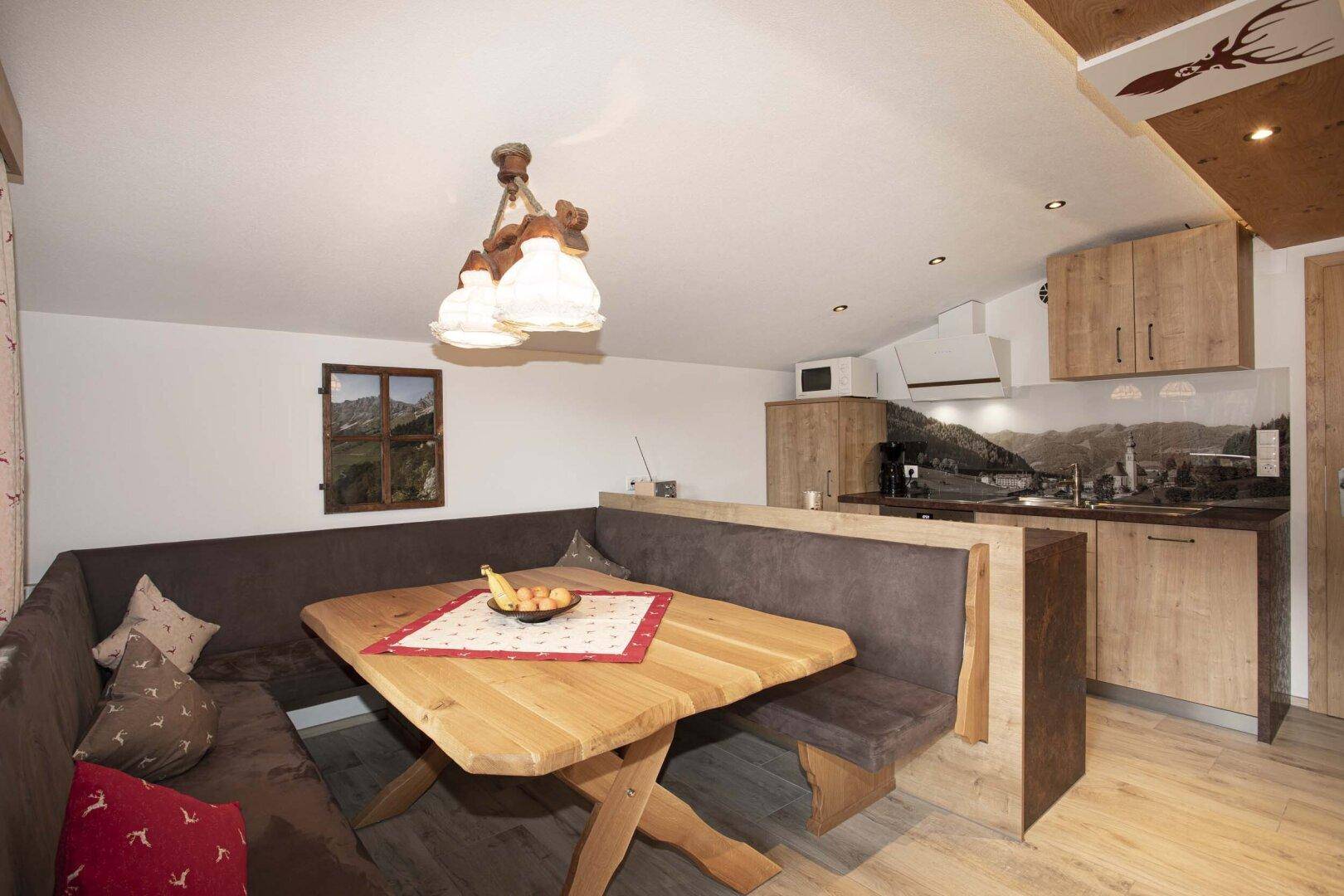 Offener Wohnbereich mit Holzküche, gemütlicher Sitzecke und Esstisch.