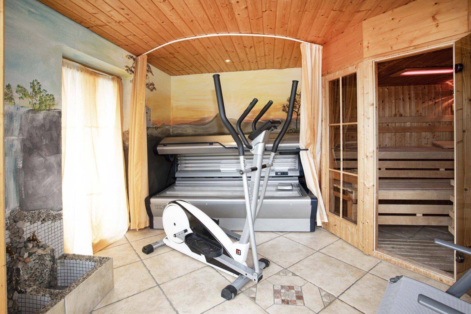 Fitnessbereich mit Crosstrainer, Solarium und Sauna.