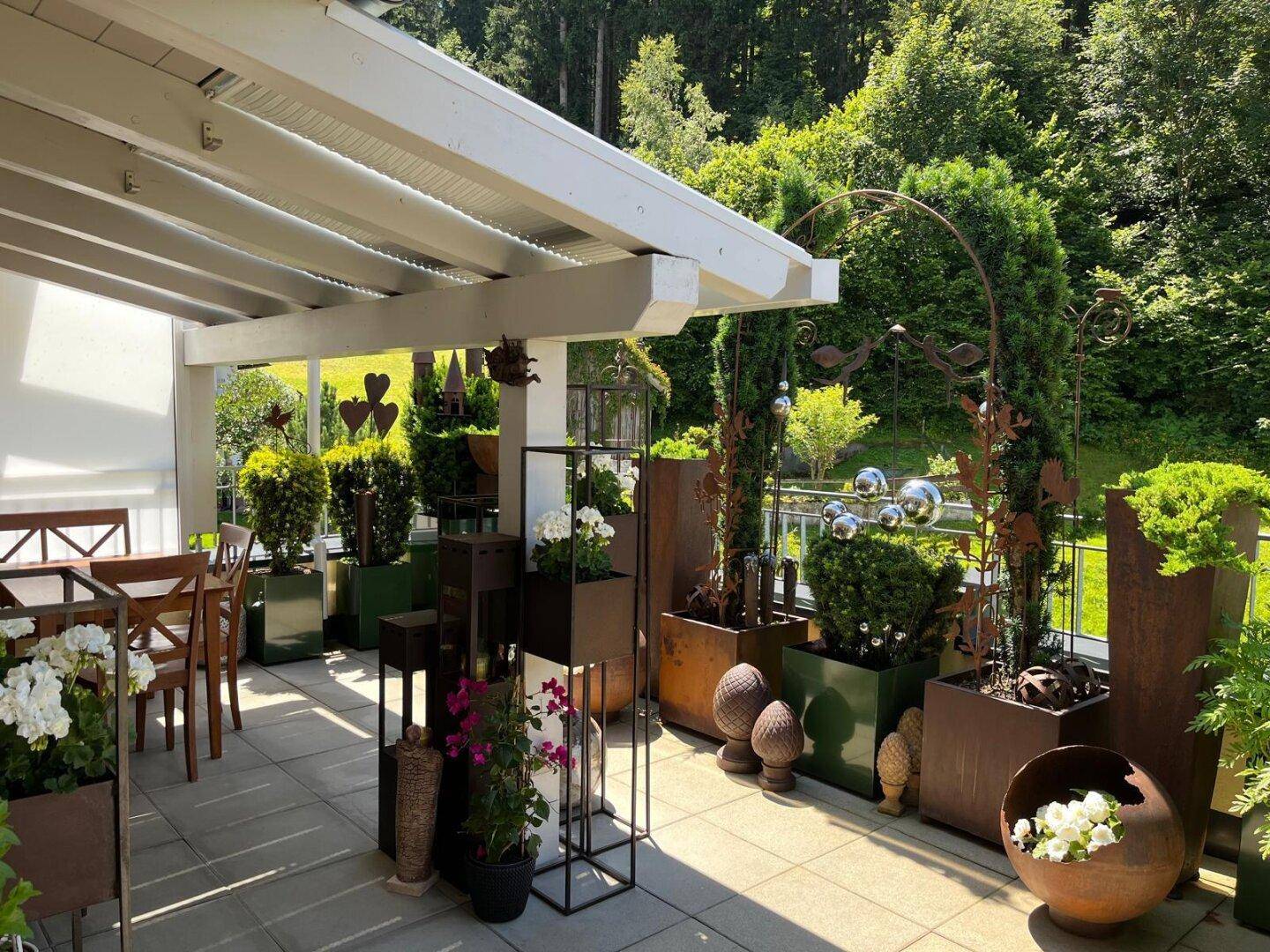 Große, begrünte Terrasse mit Sitzbereich und Blick auf den Wald, ideal für Entspannung im Freien.