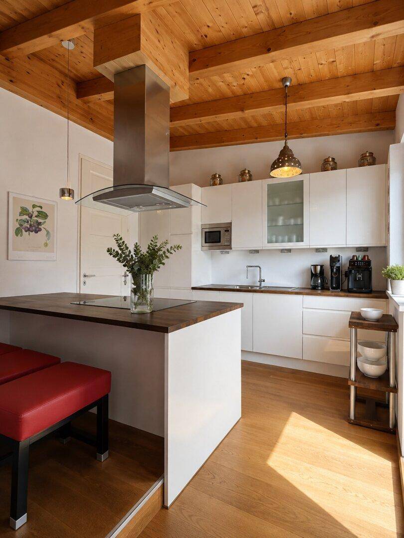 Moderne Küche mit weißen Schränken, Holzarbeitsplatte und Kochinsel unter einer Holzbalkendecke.