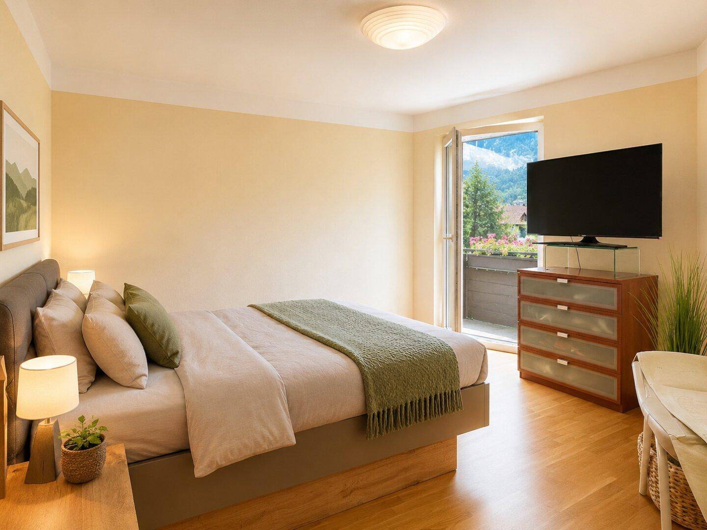 Schlafzimmer mit Doppelbett, TV, Holzboden und direktem Zugang zu einem Balkon mit Bergblick.