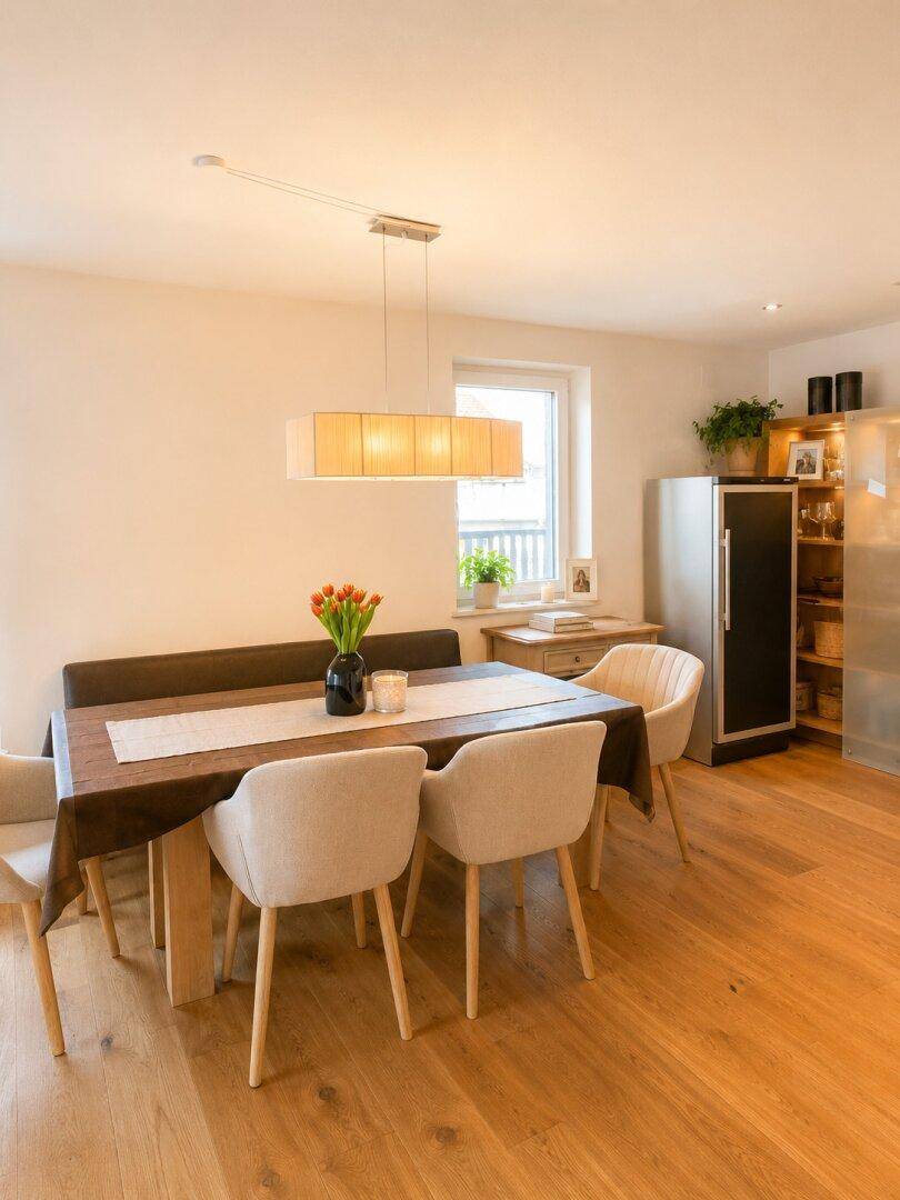 Gemütlicher Essbereich mit Holztisch, bequemen Stühlen und Fenster für natürliches Licht.