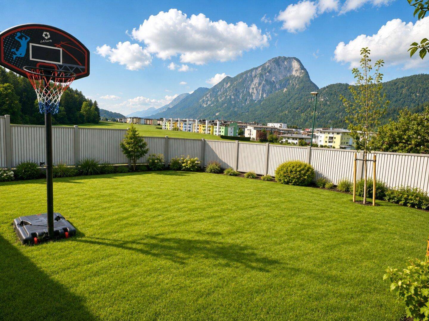 Weitläufiger Rasenbereich mit Basketballkorb und Bergblick, ideal für Freizeitaktivitäten.