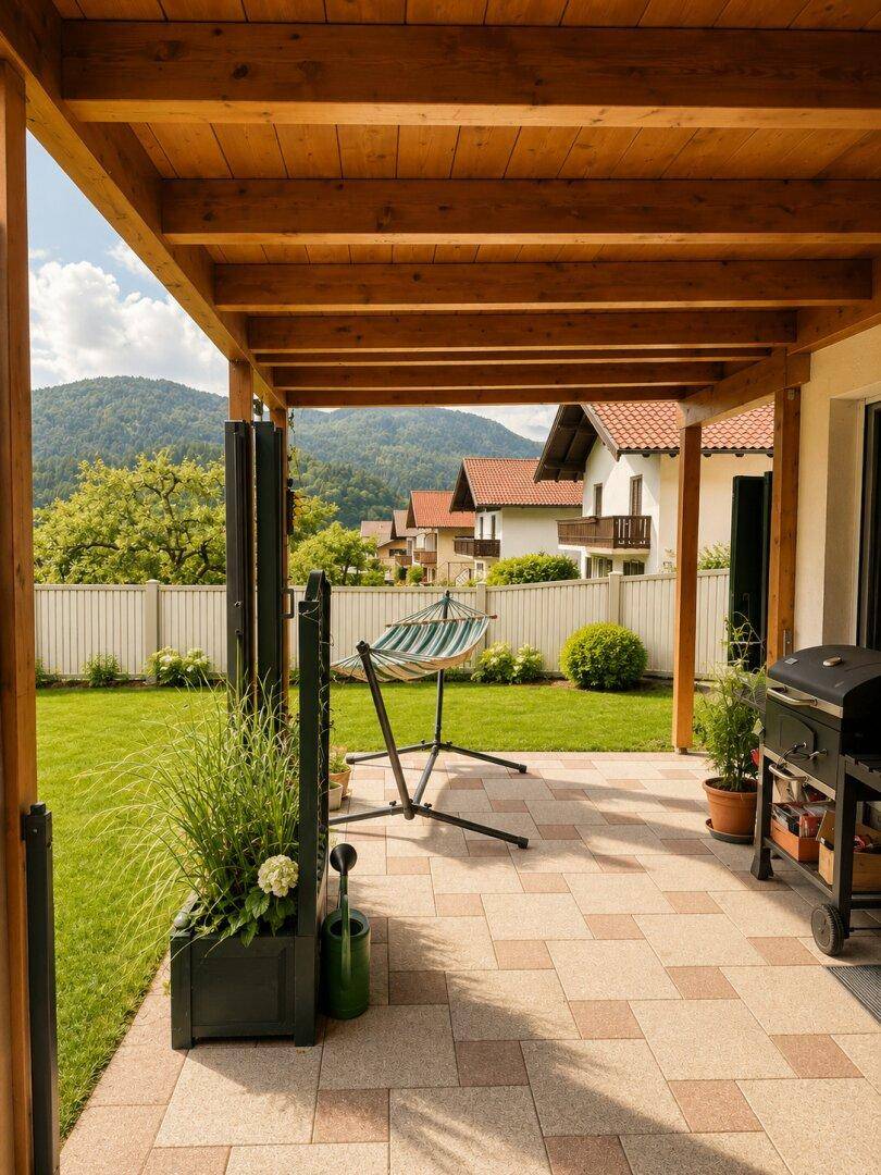 Überdachte Terrasse mit Hängematte, Grillplatz und Blick auf die umliegende Natur.