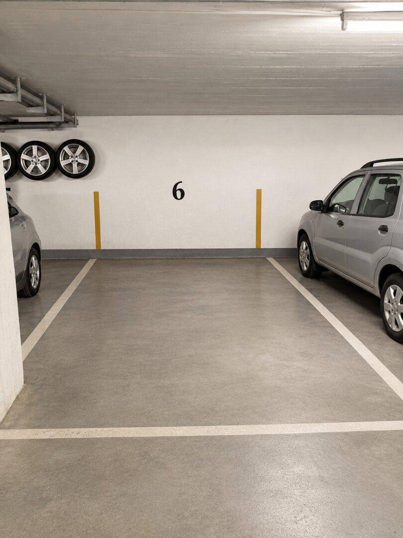 Tiefgaragenstellplatz Nummer 6 mit ausreichend Platz für ein Fahrzeug und Reifenlagerung.